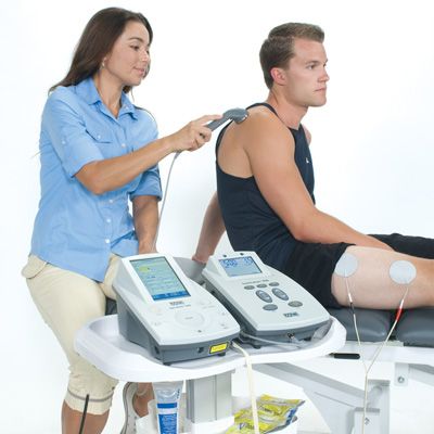 Female Doctor with Senior at Electrotherapy for Pain Relief Stock